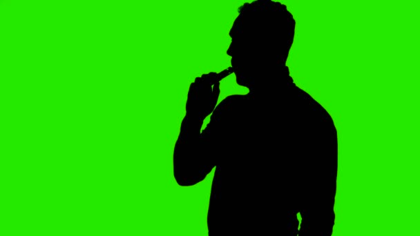 Video van hoesten mans silhouet met vape op groene achtergrond — Stockvideo