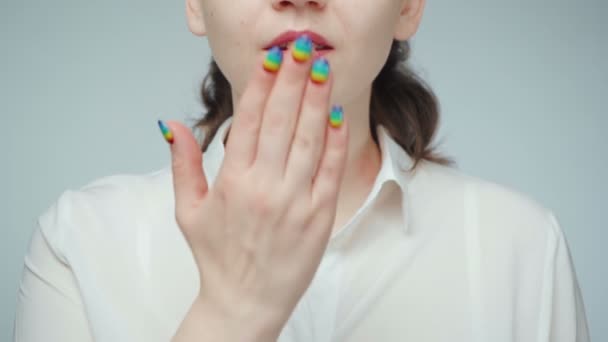 Shooting of woman with rainbow nails doing air kiss — Stock Video