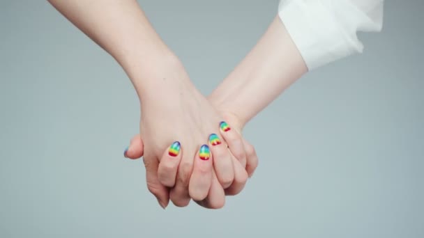 Žena s duhovými nehty drží ruku s jinou ženou — Stock video