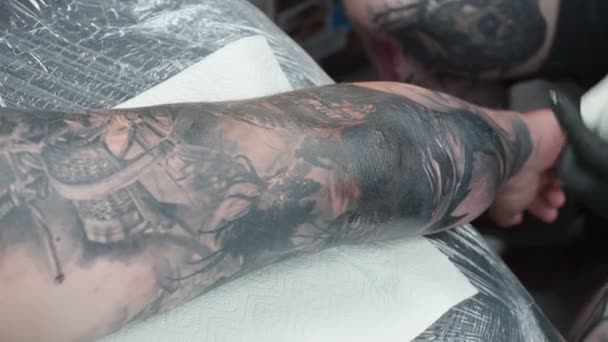 Видеозапись того, как мастер делает татуировку на коже в салоне — стоковое видео
