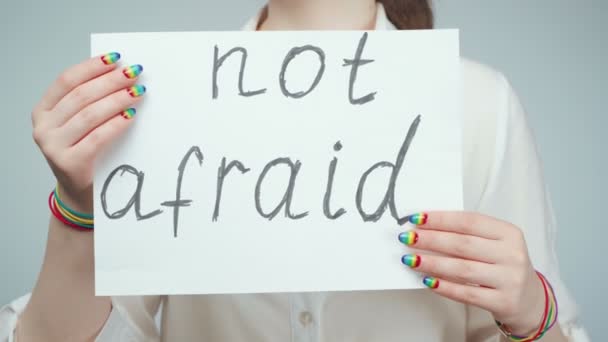 Shooting of girl with rainbow nail holding poster — Stok Video