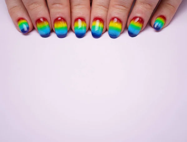 Photo of womans hands with rainbow nails on top — Stock Photo, Image