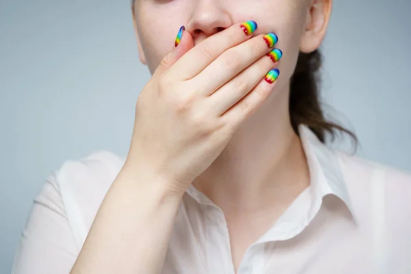 Beeld van vrouw met regenboog manicure die haar mond — Stockfoto