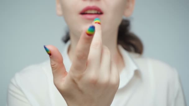 Záběry ženy s duhou manikúrou vábící prst — Stock video