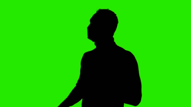 Footage of mans silhouette undressing protective mask on green background — Stock Video