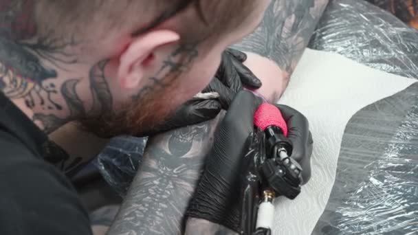 Video di master che si tatuano sul gomito nel salone, vista dall'alto — Video Stock