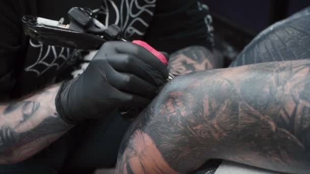 Стрельба человека, делающего татуировку на руке в салоне — стоковое видео