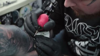 Kuaförde bir adamın cildine dövme yaptırması.