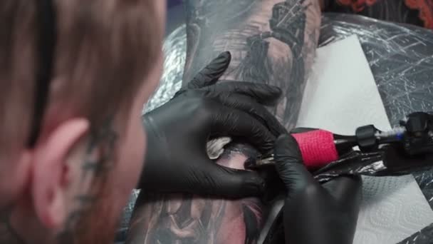 Vídeo de tatuador recebendo tatuagem na pele no salão — Vídeo de Stock