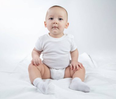 Beyaz arka planda dokuz aylık bir bebeğin fotoğrafı.