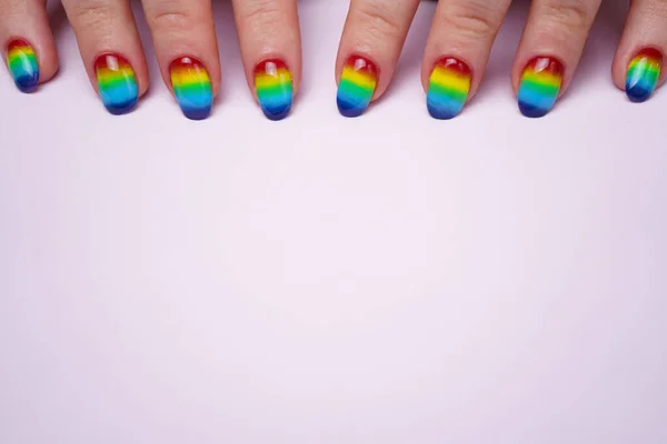 Afbeelding van vrouwen handen met regenboog nagels op de top — Stockfoto