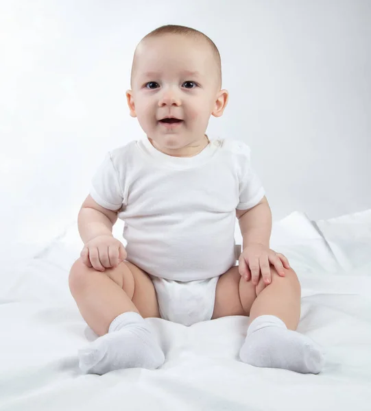 Imagem de um bebê de nove meses sentado em um fundo branco — Fotografia de Stock