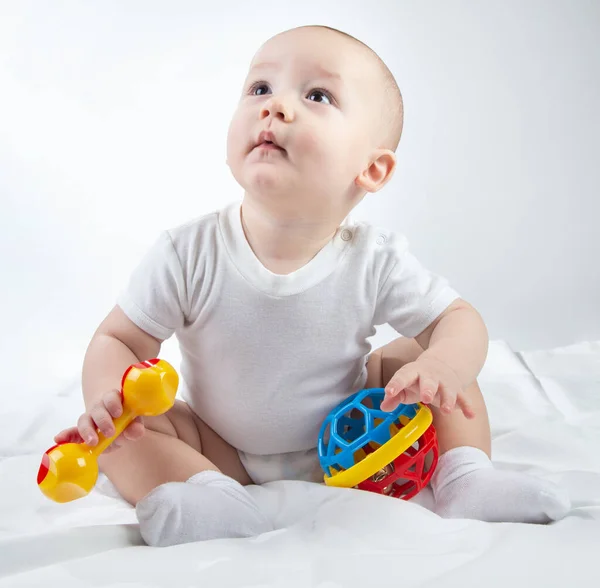 Photo of a looking up nine-month-old baby with rattle — Stock Photo, Image