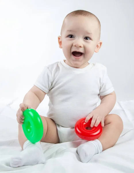 Foto de um bebê de nove meses com brinquedos brilhantes — Fotografia de Stock