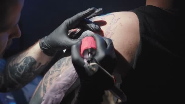 Lelőni egy tetoválót egy férfi vállára tetováltatva egy szalonban.