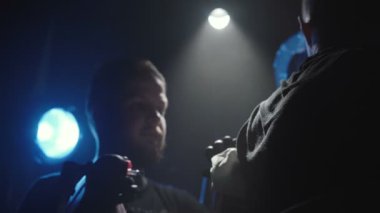 Bir adamın omzuna dövme yaptıran bir dövmeciyi vurmak.