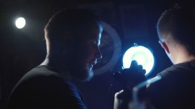 Genç bir adamın omzuna dövme yaptıran bir dövmenin görüntüsü.