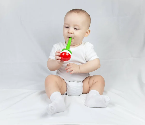 Photo of a eight month old baby with bright rattle — Stock Photo, Image