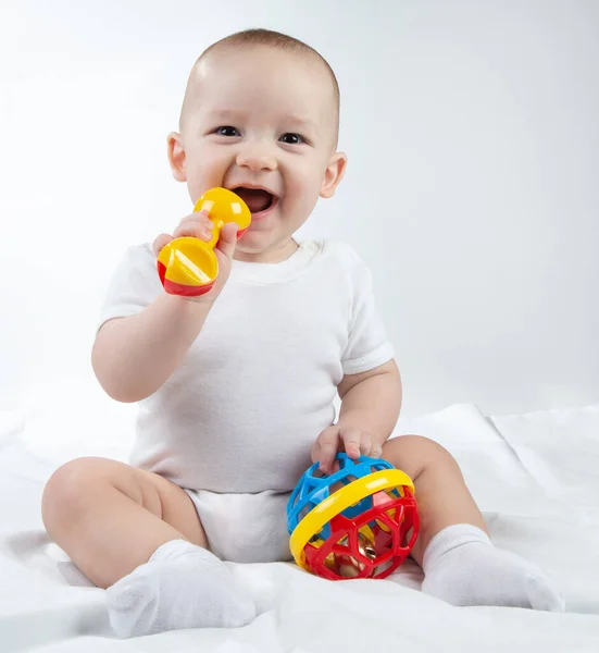 Image of a nine-month-old baby with rattle in the mouth — Stock Photo, Image