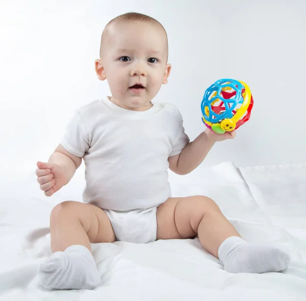 Photo of a nine-month-old baby holding rattle — Stock Photo, Image