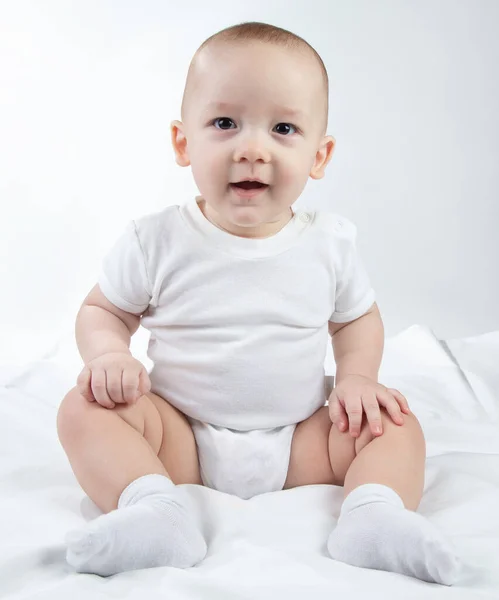 Foto de um bebê de nove meses sentado em um fundo branco — Fotografia de Stock