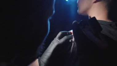 Adamın omzuna dövme yaptıran bir profesyonelin görüntüsü.