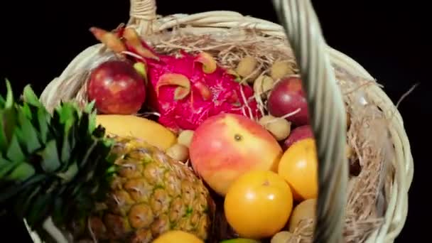 Primer plano de vídeo de hilado cesta de mimbre con frutas exóticas — Vídeos de Stock