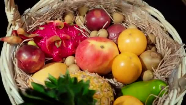 Крупный план крутящейся плетеной корзины с экзотическими фруктами — стоковое видео