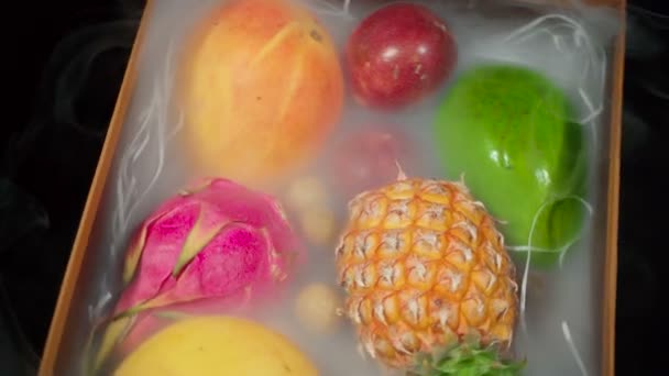 Video de caja giratoria con frutas exóticas en humo — Vídeo de stock