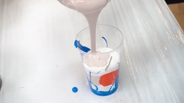 Beelden van het mengen van acrylverf in plastic beker — Stockvideo