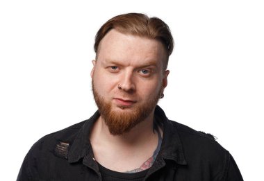 Siyah kot ceketli, kaşlarını çatmış adamın resmi.