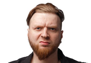 Siyah kot ceketli, sakallı, tatminsiz bir adamın portresi.