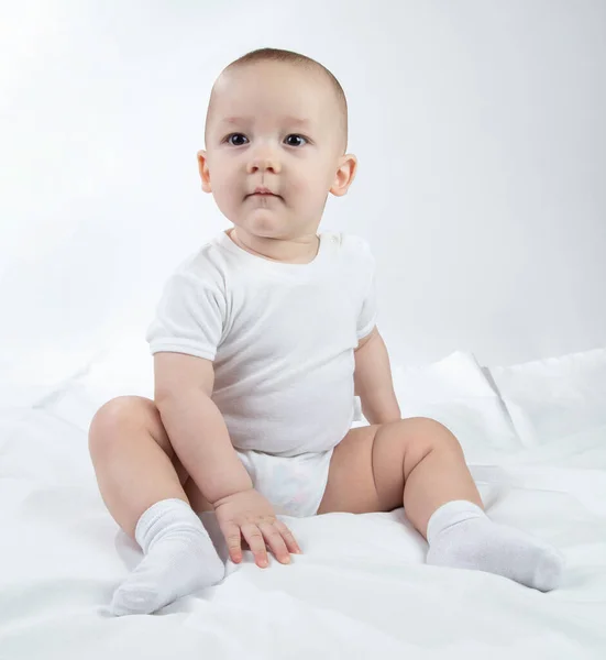 하얀 배경에 앉아 있는 9 개월된 남자 아이의 사진 — 스톡 사진