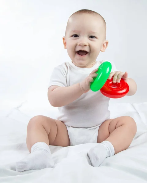 Photo of a smiling nine-month-old baby with bright toys — Stock Photo, Image