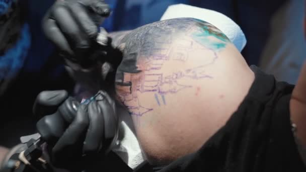 Запись татуировщика, делающего татуировку на плече молодого человека в салоне — стоковое видео