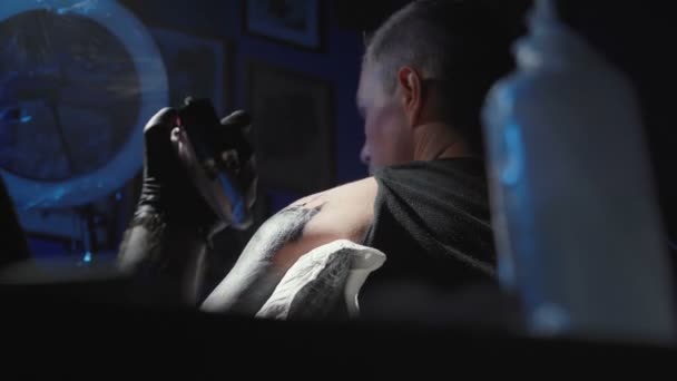 Dövmeci genç bir adamın omzuna dövme yaptırıyor. — Stok video
