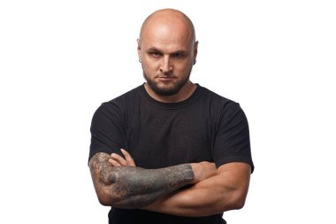 Beyaz arka planda siyah gömlekli kel, ciddi bir adamın fotoğrafı.