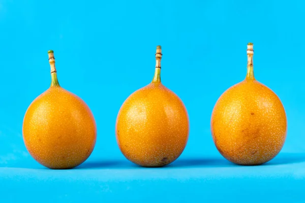 Foto de granadilla fresca madura sobre fondo azul —  Fotos de Stock