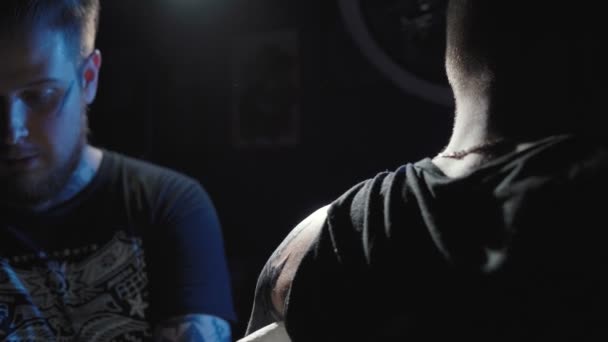 Filmación de un tatuador haciendo un tatuaje en un hombro de hombre — Vídeos de Stock