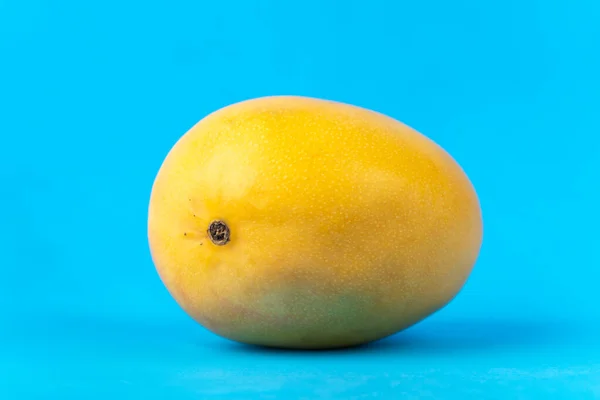 青い背景に熟した黄色のマンゴーの写真 — ストック写真
