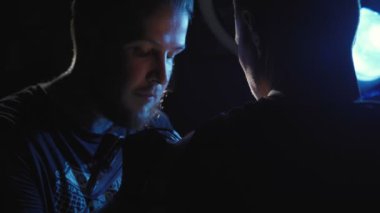 Bir adamın omzuna dövme yapan bir dövmeciyi vurmak.