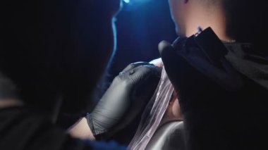 Adamın omzuna dövme yaptıran bir profesyonelin videosu.