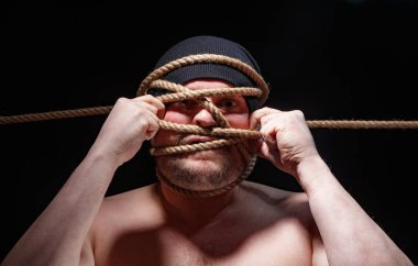 Kafasında iple bağlanmış şişman adam.