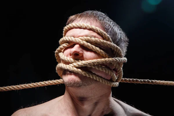 Yüzü iple bağlanmış korkunç bir adamın resmi.