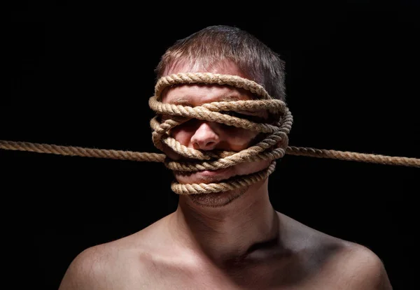 Изображение связанного страшного человека с веревкой на лице — стоковое фото