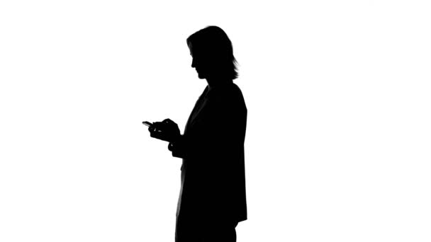 Video of womans silhouette talking on phone in suit jacket — Stock Video