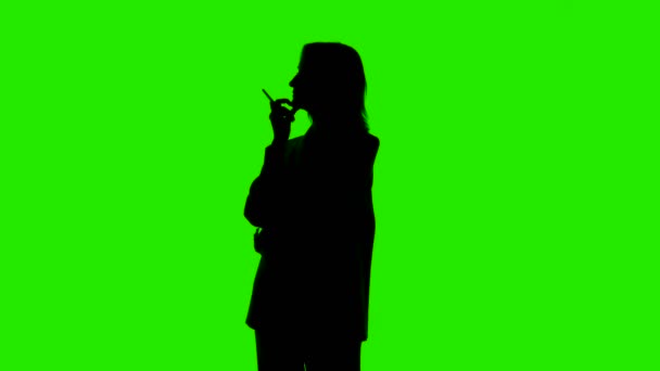 Video of pointing up womans silhouette in suit jacket on green background — Stock Video