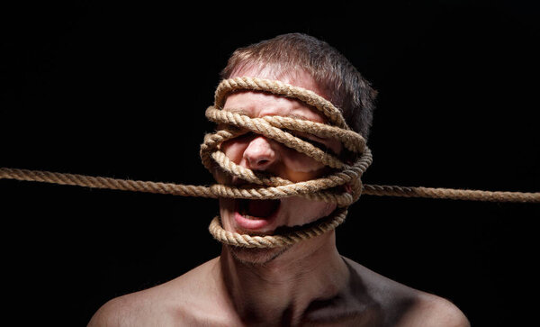 Photo of binded screaming man with rope on face