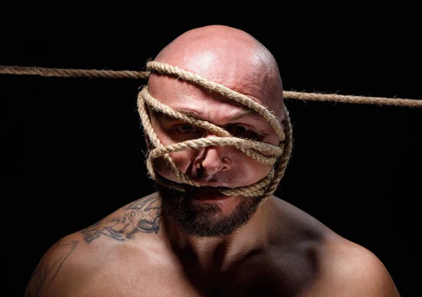 Foto de homem careca amarrado assustador com corda no rosto — Fotografia de Stock