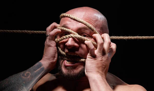 Photo of binded screaming bald man with rope on face — Stock Photo, Image